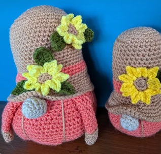 Sunny and Marigold, a pair of crocheted gonks in pink and grey with crocheted sunflowers on their hats